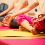 Group of people sitting in lotus position in the fitness studio