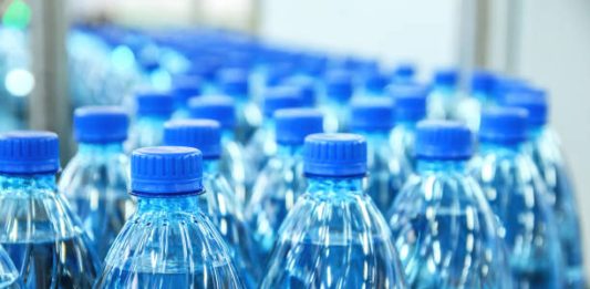 Closeup on mineral water green bottles in raw and lines
