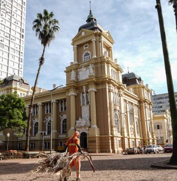 Foto: Gari faz limpeza no entrono do Museu de Arte do Rio Grande do Sul, na praça da Alfândega, em Porto Alegre - Carlos Macedo/Carlos Macedo/Folhapress